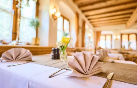 Tisch im Restaurant mit gefalteten Servietten und Blumen, ideal für ein gemütliches Essen im Familienurlaub.