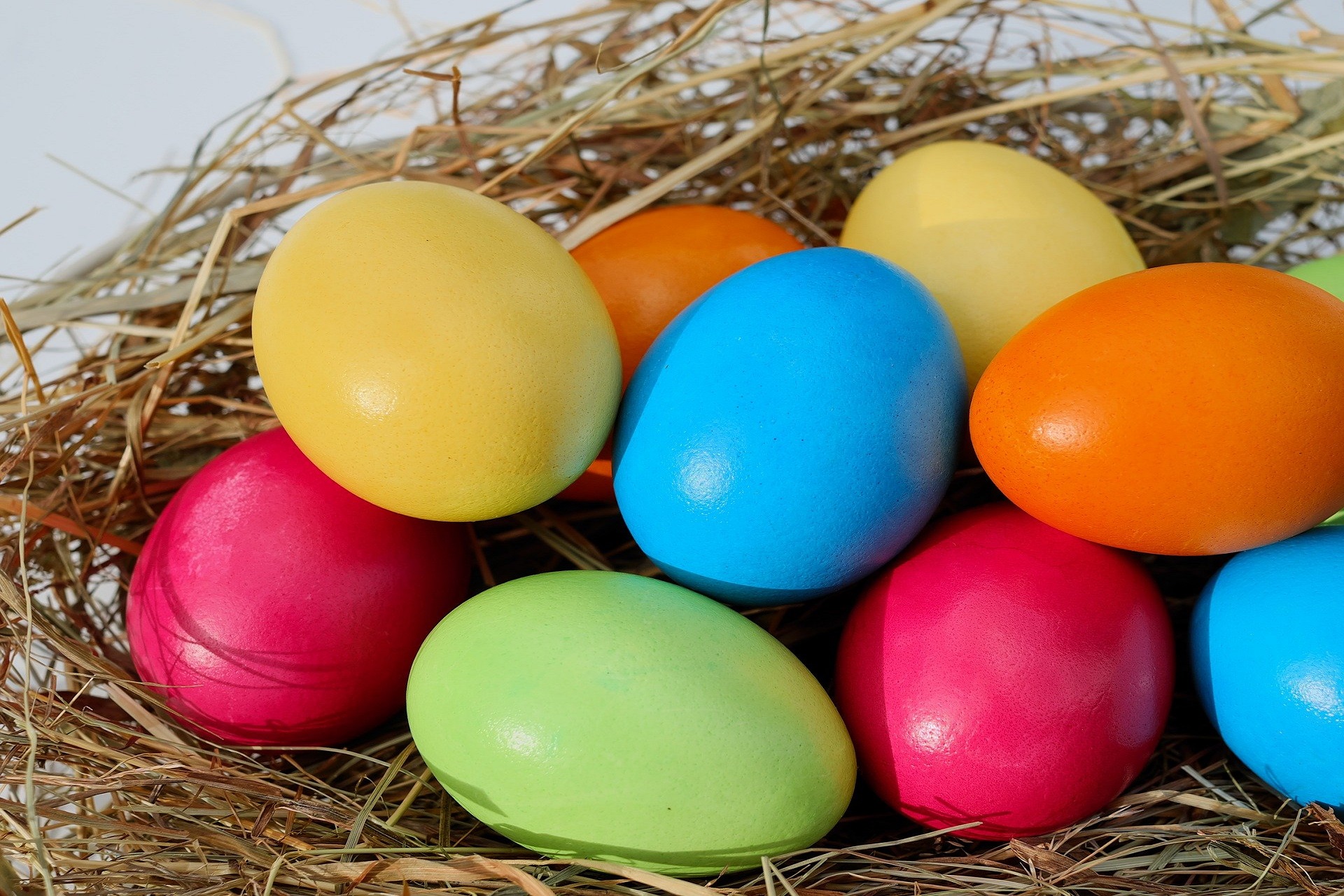 Bunte Ostereier in einem Nest aus Stroh, ideal für die Osterdekoration und Festlichkeiten im Frühling.