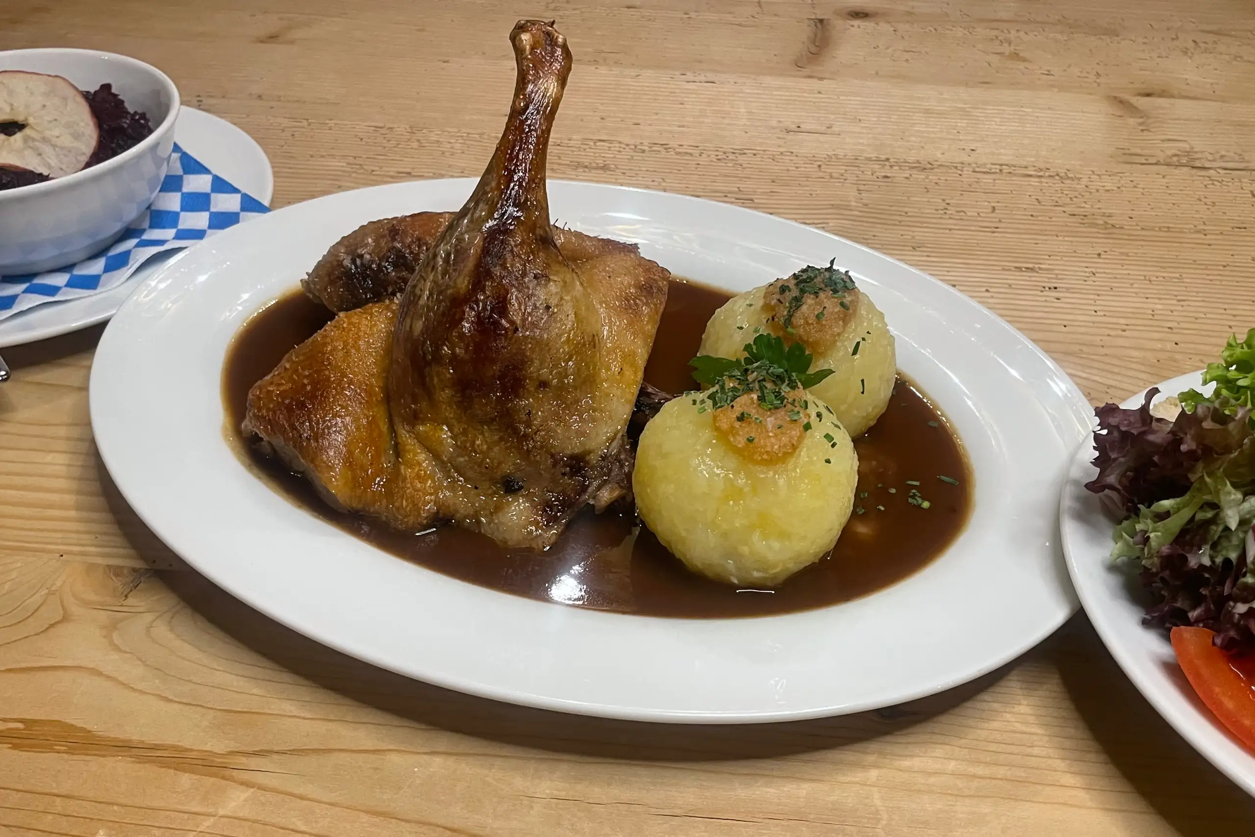 Delikate Entenbrust mit zwei Knödeln und Soße, serviert in einem bayerischen Restaurant, ideal für Feinschmecker.