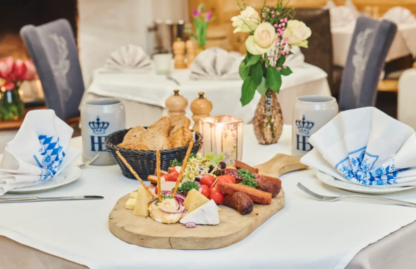 Ein reichhaltiges Käse- und Wurstbrett im Restaurant des Hotel Alpenglück, umgeben von frischem Brot und Dekoration.