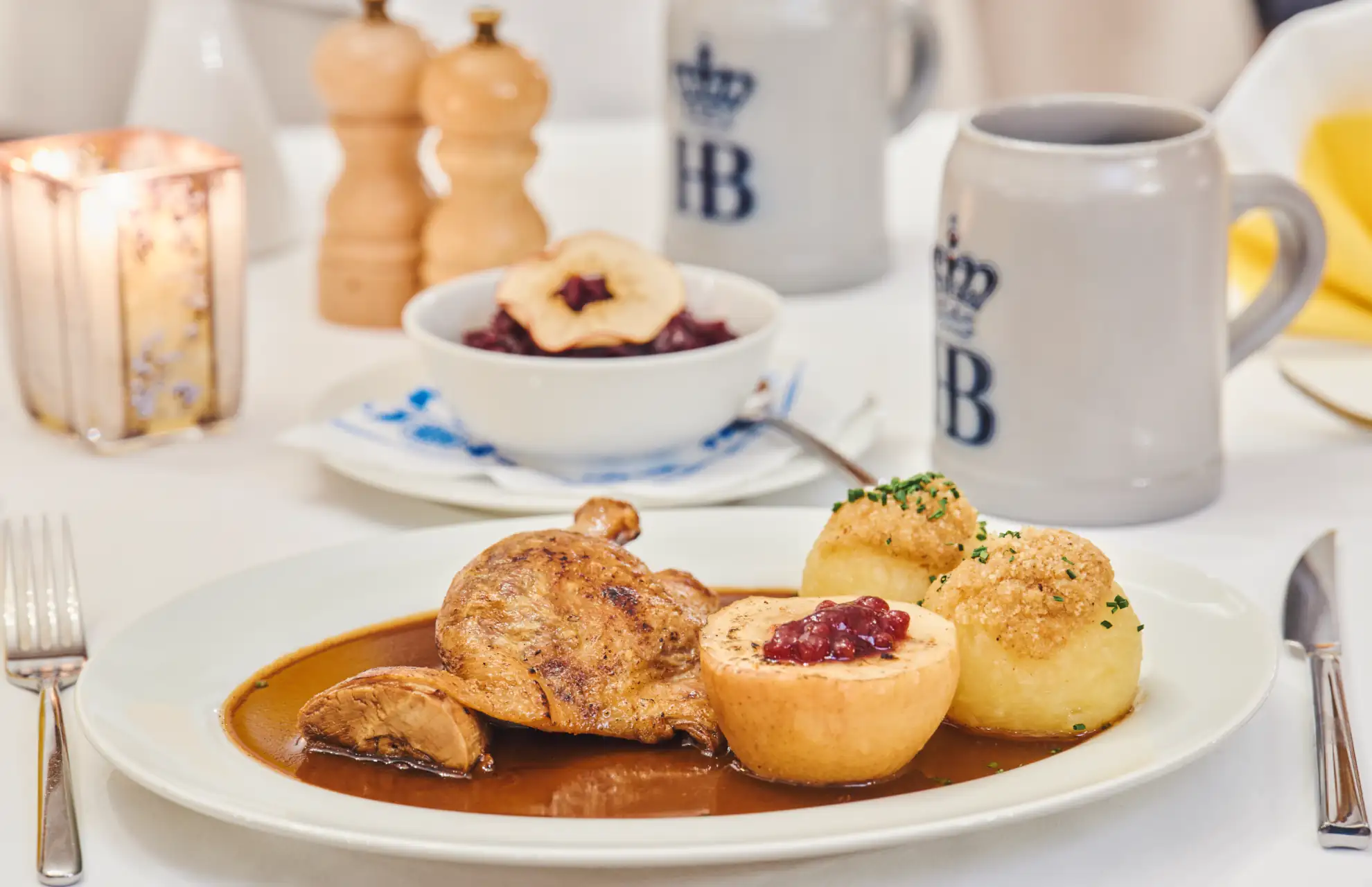 Brathähnchen mit Knödeln und Preiselbeeren im Restaurant, ideal für einen kulinarischen Genuss während des Urlaubs.