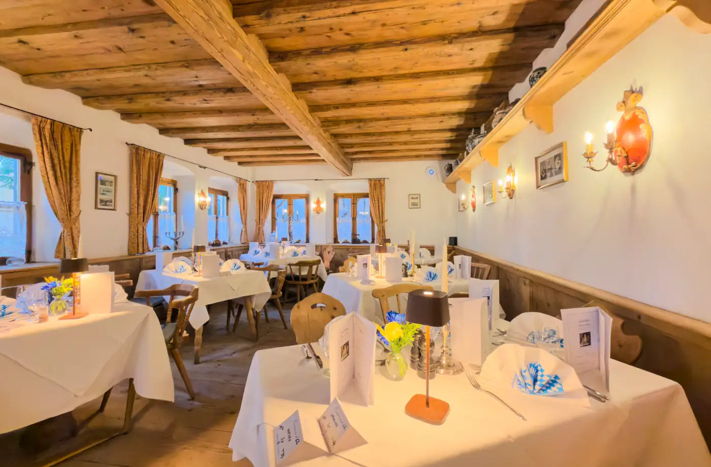 Gemütliches Restaurant im Hotel Alpenglück mit rustikalem Ambiente und geschmackvoll gedeckten Tischen Im Restaurant des Hotel Alpenglück in Bayern erwartet Gäste ein rustikales Ambiente mit liebevoll gedeckten Tischen für einen angenehmen Aufenthalt.