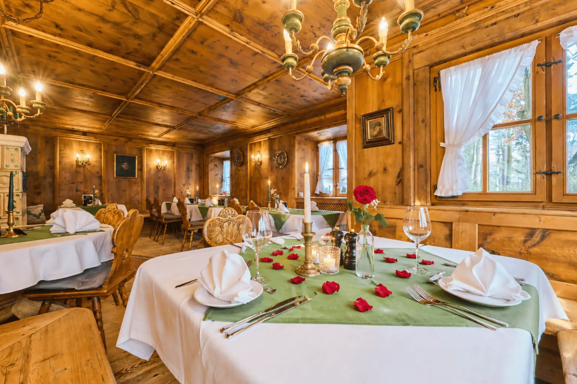 Einladende Tafel im Restaurant des Hotels mit Rosendekoration, Kerzenlicht und eleganten Tischgedecken für ein romantisches Dinner.