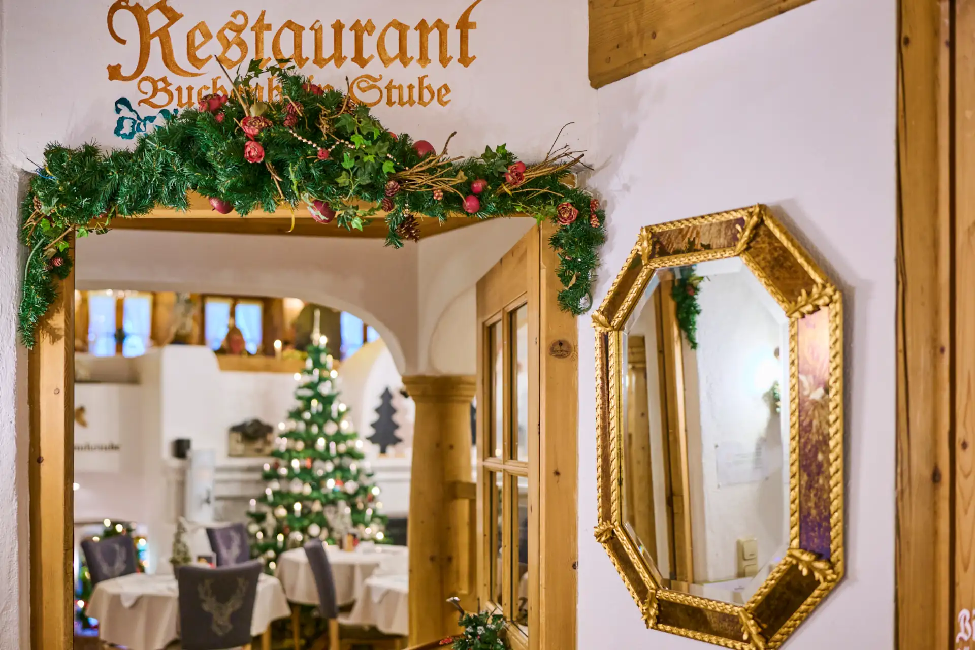 Der Speiseraum in der Buchluft-Stube zeigt festlich gedeckte Tische und einen Weihnachtsbaum, ideal für Familienfeiern.