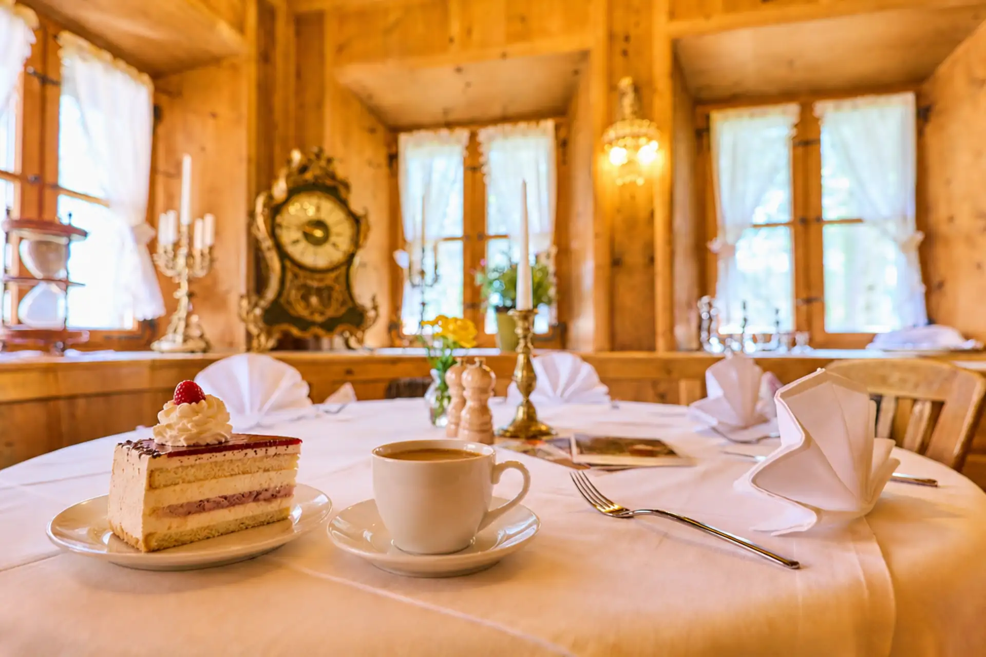 Genuss von Kaffeetasse und Torte in einem traditionellen Restaurant mit Holzinterieur, ideal für Familienurlaub und gemütliche Auszeiten.