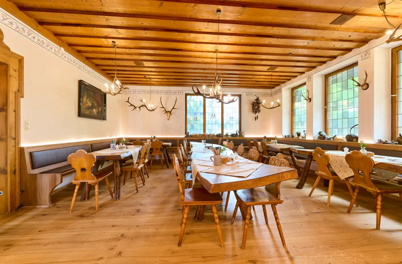 Gemütliches Restaurant im Hotel Alpenglück mit rustikalem Ambiente und holzverkleideten Tischen Gemütliches Restaurant im Hotel Alpenglück, eingerichtet mit Holzstühlen und rustikalen Tischen für eine warme Atmosphäre während des Familienurlaubs.