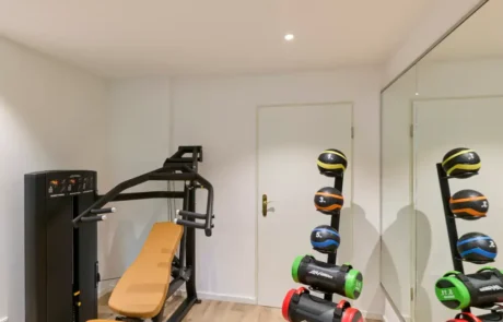 Fitnessraum mit moderner Ausstattung für effektives Training und Wohlbefinden Der Fitnessraum bietet ein Trainingsgerät und unterschiedliche Hanteln für ein effektives Training im Hotel.
